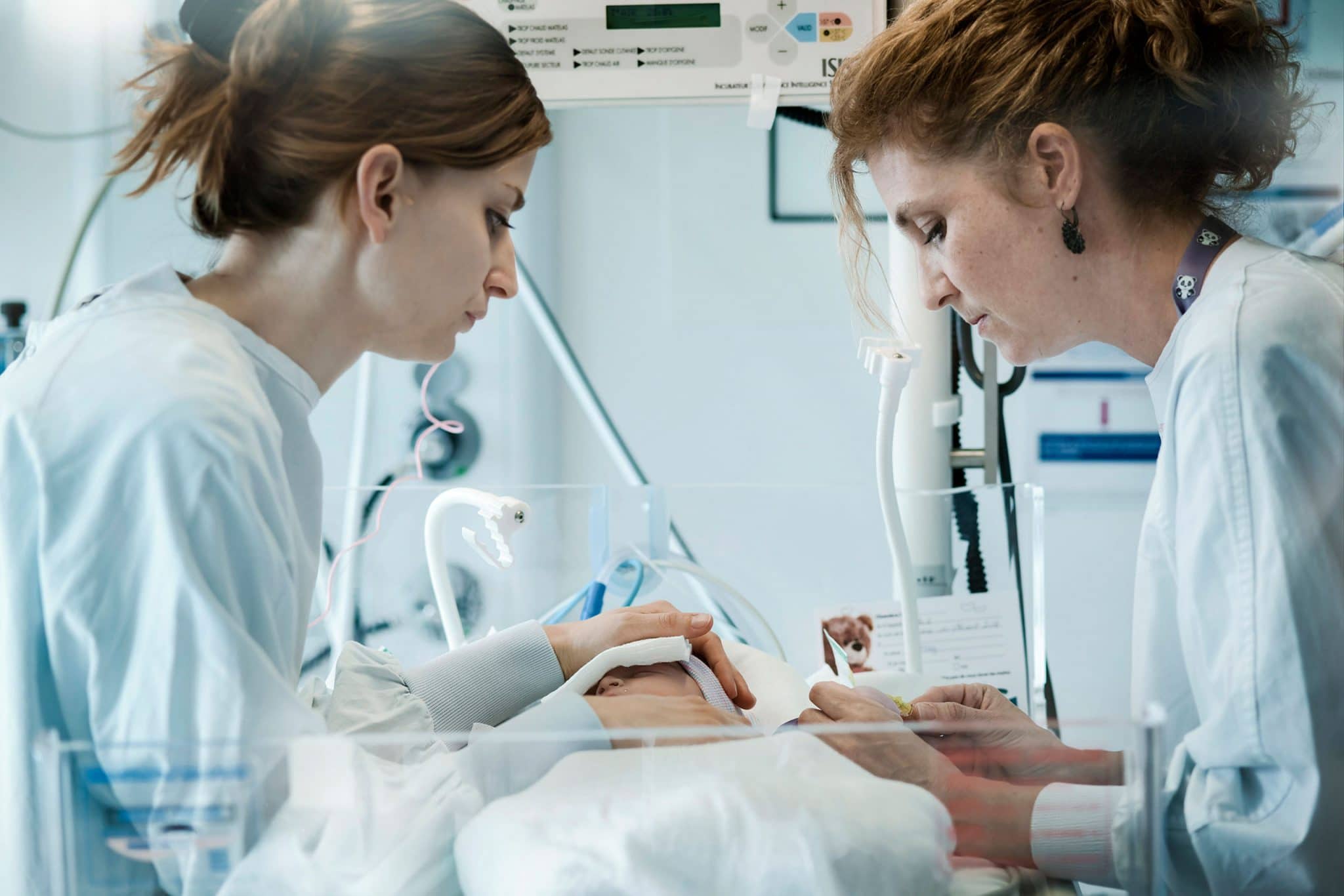 reportage photo sur les professionnels de la santé en milieu hospitalier. 2 aide-soignantes prodigue les premiers soins à un nouveau-né
