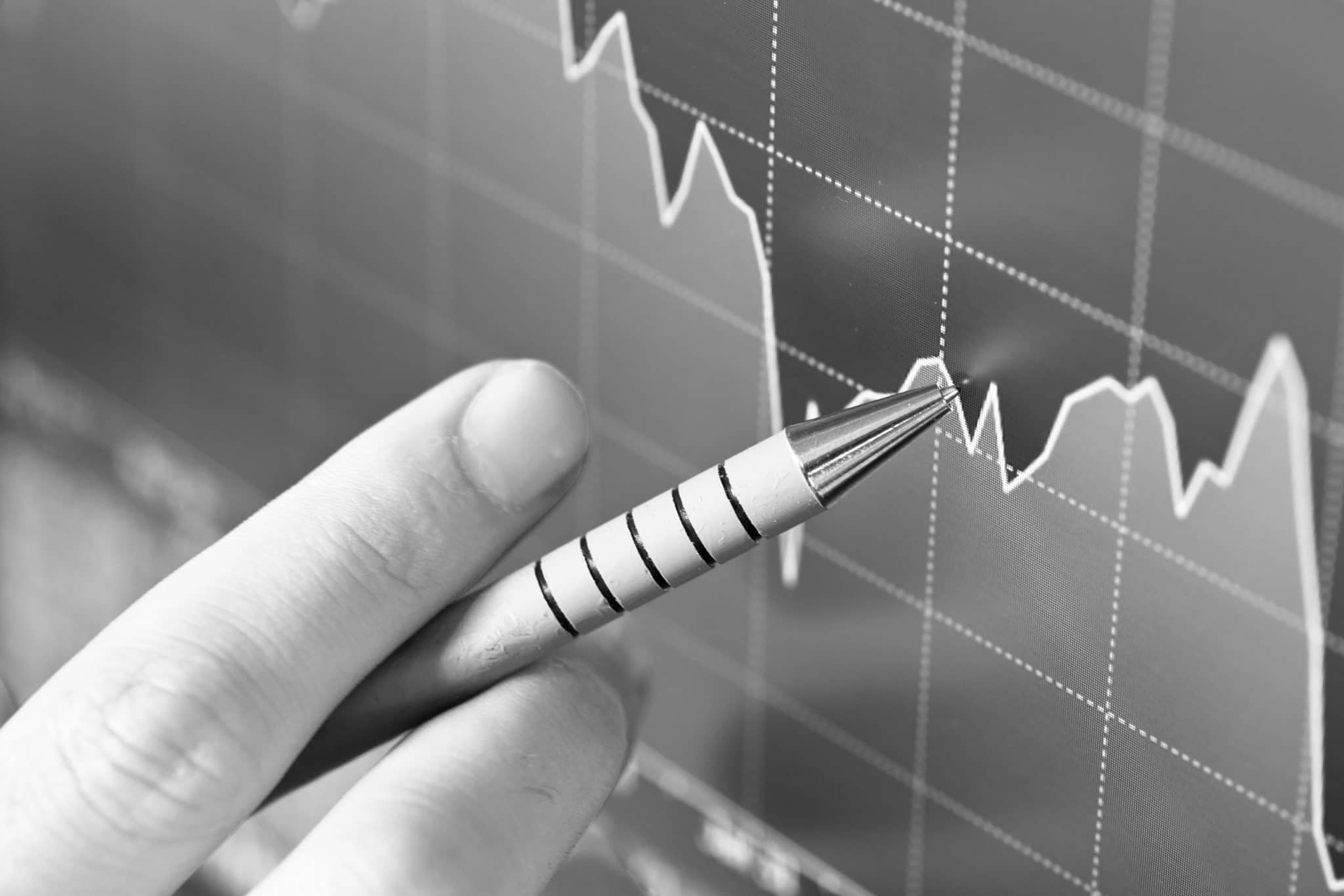 détail d'un stylo pointant un écran. Courbe statistiques