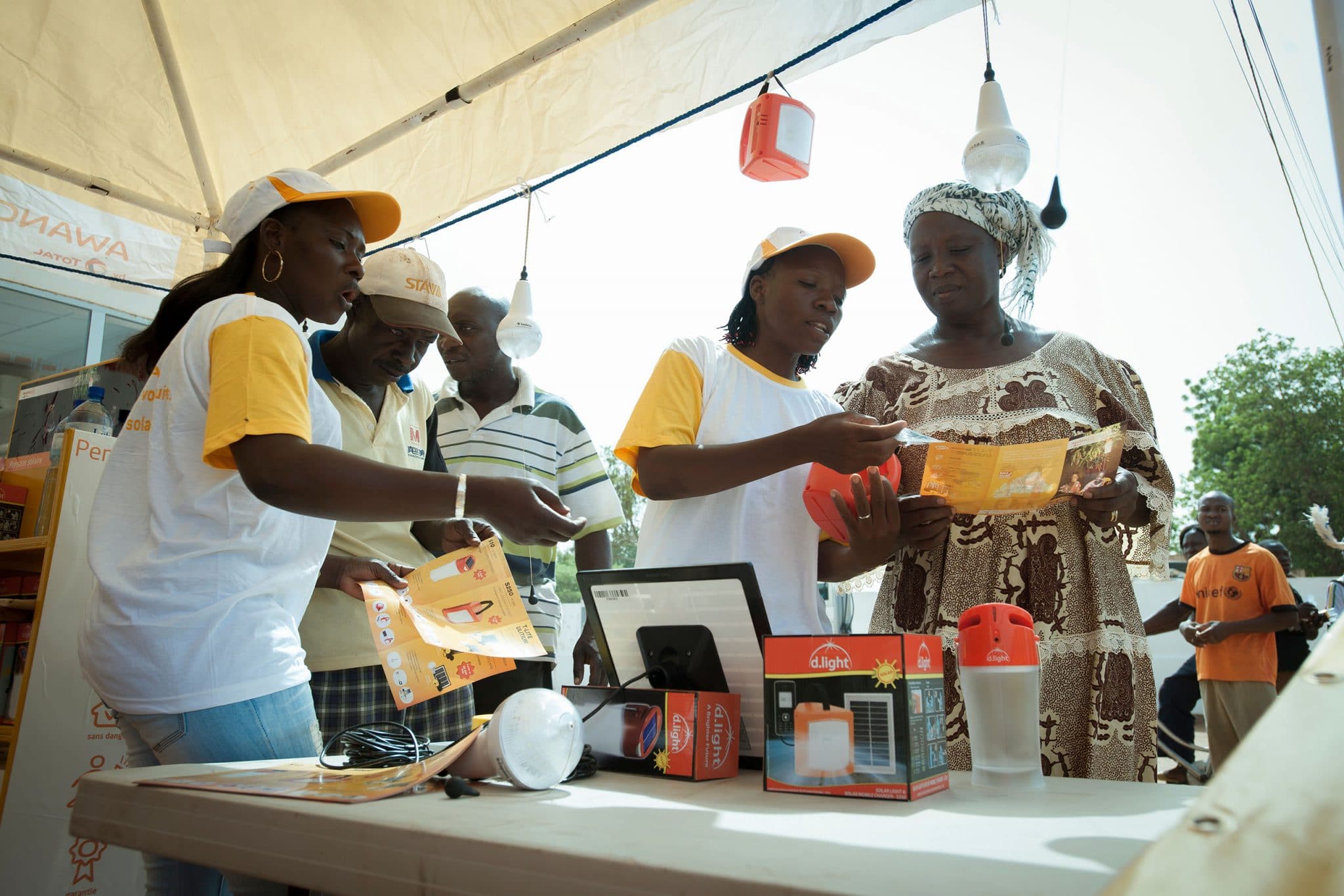 des démonstratrices vendent des lampes solaires Awango by TotalEnergies dans une station service de Ouagadougou au Burkina Faso