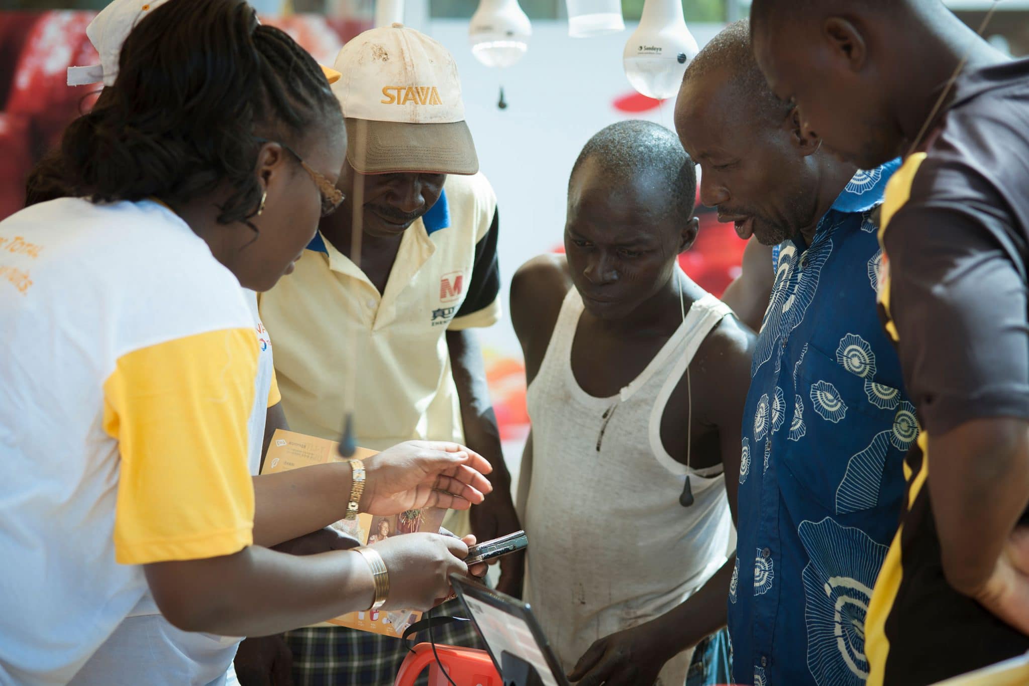 Une demonstratrice expilque le fonctionnement des lampes solaires Awango By TotalEnergies