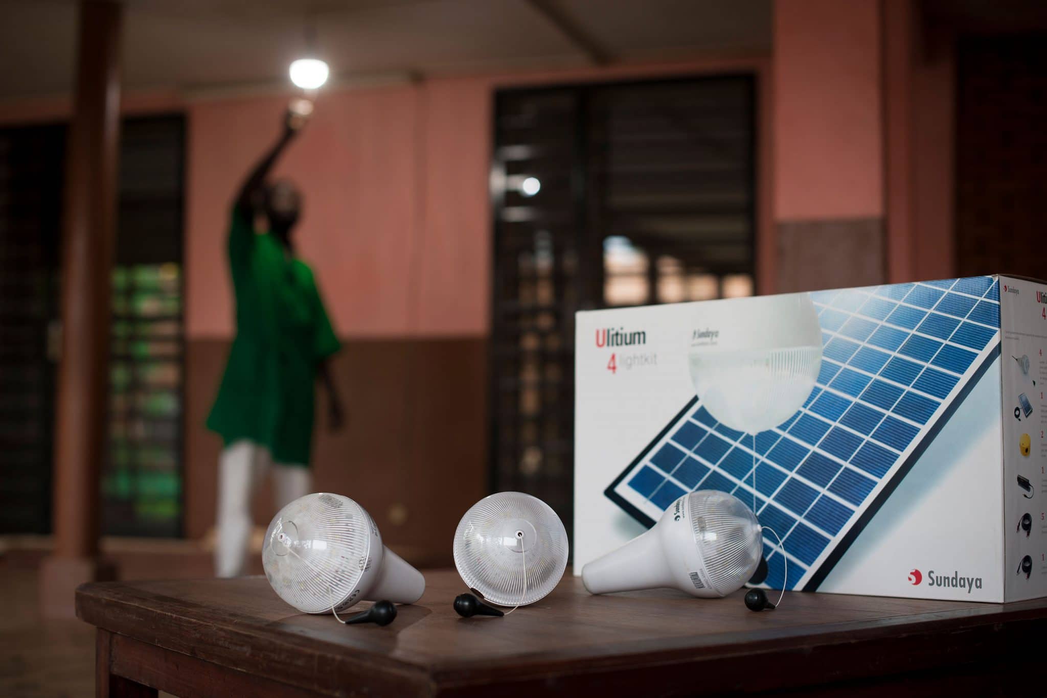 A Ouagadougou , des installateurs partenaires de TotalEnergies viennent mettre en place le kit de 4 lampes solaires Sundaya dans une maison.