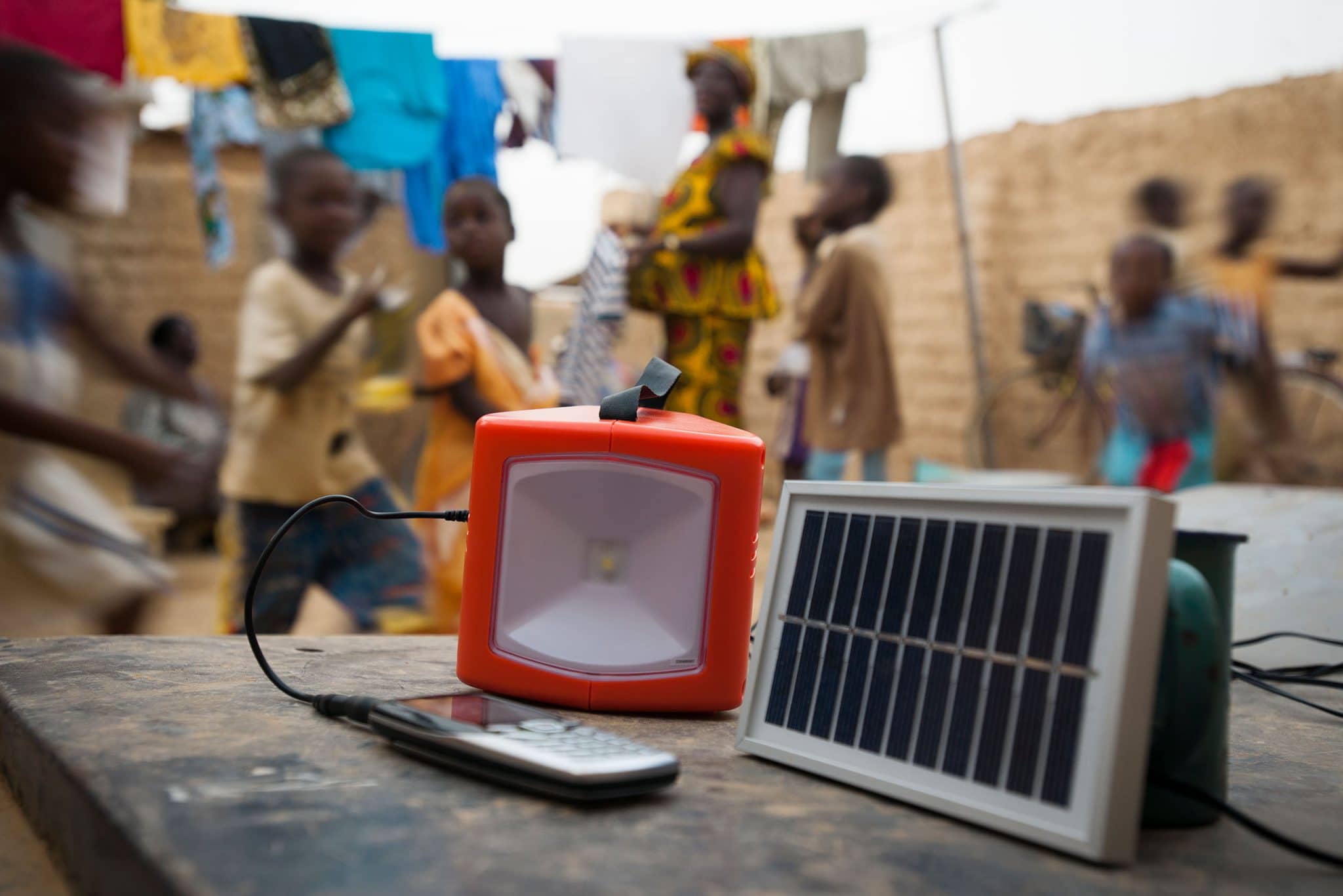 Dans les faubourgs de Ouagadougou, dans un quartier non loti - non électrifié - chez M. Sawadogo et Mme Ouedraogo, une lampe Awango by TotalEnergies se recharge grâce à l'énergie solaire