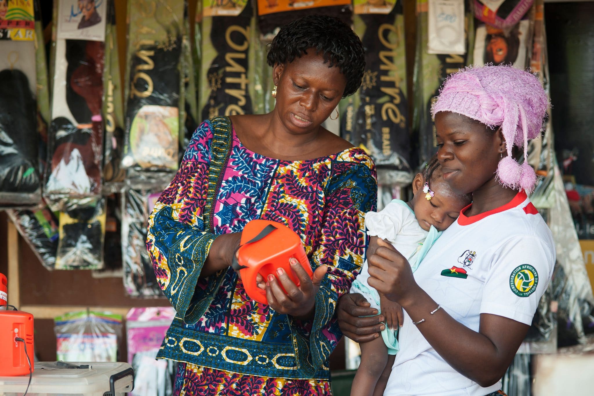 a Kossodo, dans les faubourgs de Ouagadougou. Une cliente, Rokia GUE désirant acheter une lampe solaire S250 à Gilberte NANEMA, boutiquière .