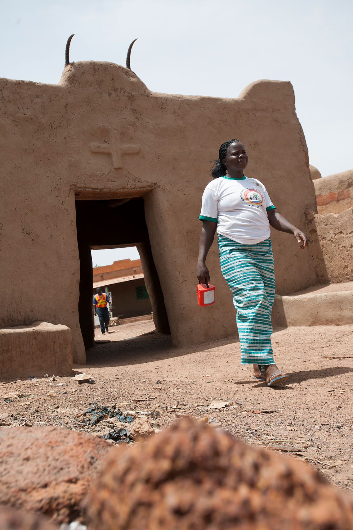 A Réo, à 120km de Ouagadougou, Jeanne KANYALA marche avec la lampe solaire S250.