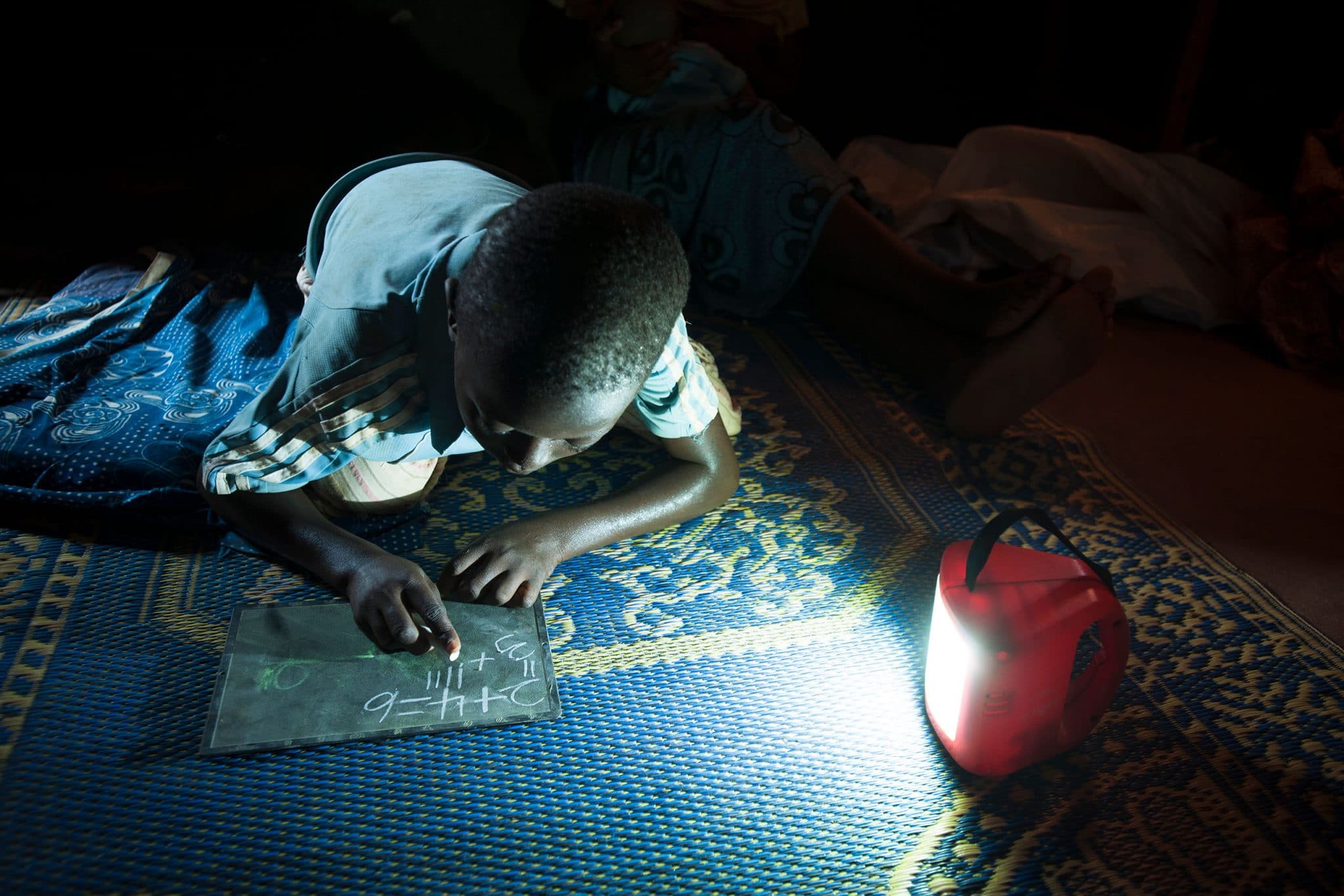 A Réo, à 120km de Ouagadougou, chez Jeanne KANYALA dont la maison n'est pas reliée au reseau électrique. Son fils Kanzie peut réviser ses leçons, une fois le nuit tombée grace à Awango by TotalEnergies