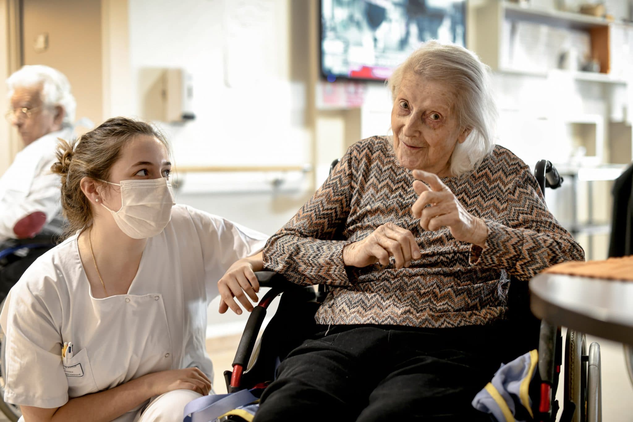 Reportage Santé professionnel en Maison de Retraite. EHPAD de Neuilly sur Seine. Une résidente sous le regard bienveillant dune aide-soignante.