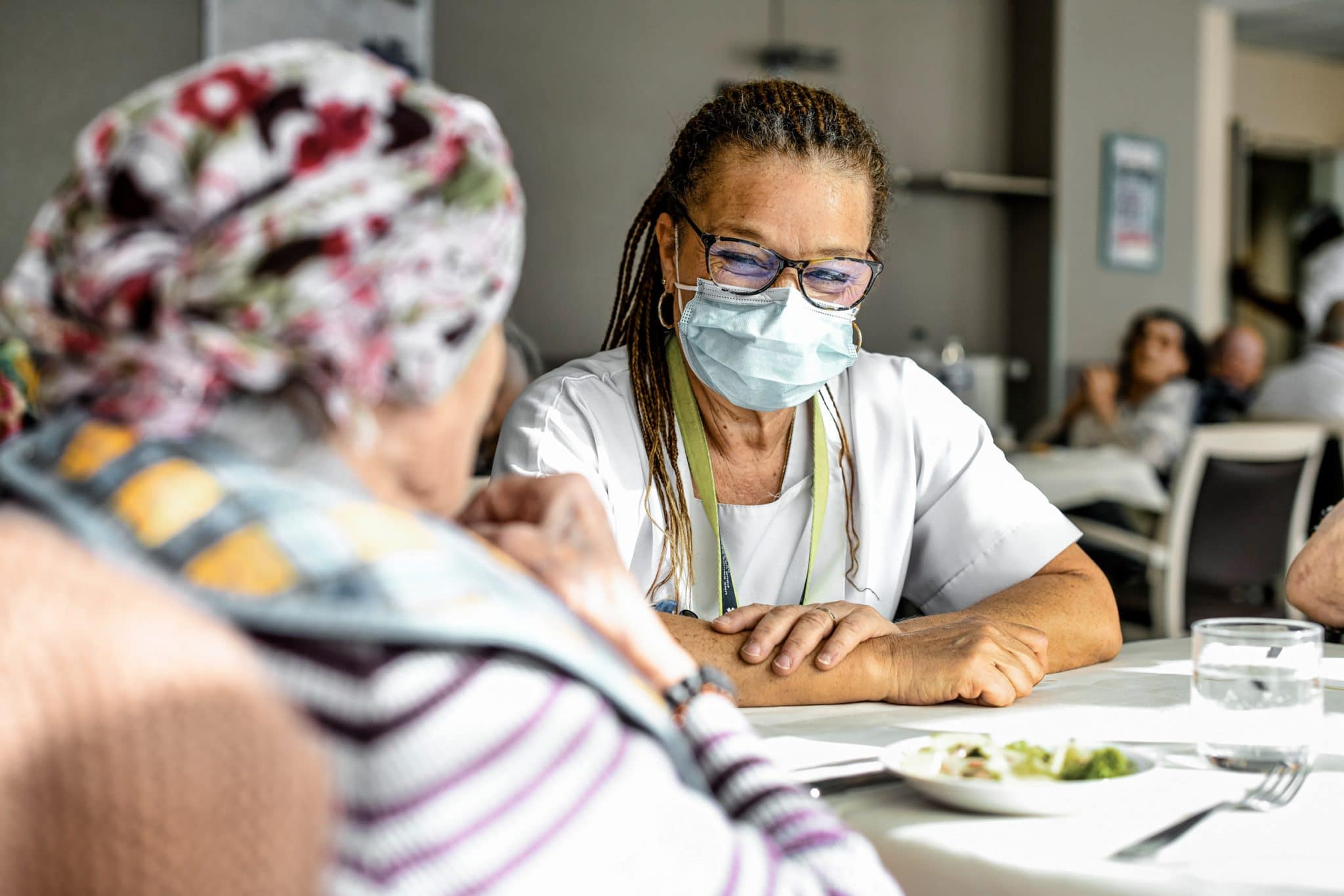 EHPAD La Méridienne. Accompagnement du repas par une aide-soignante. Photographe portrait en Ehpad.