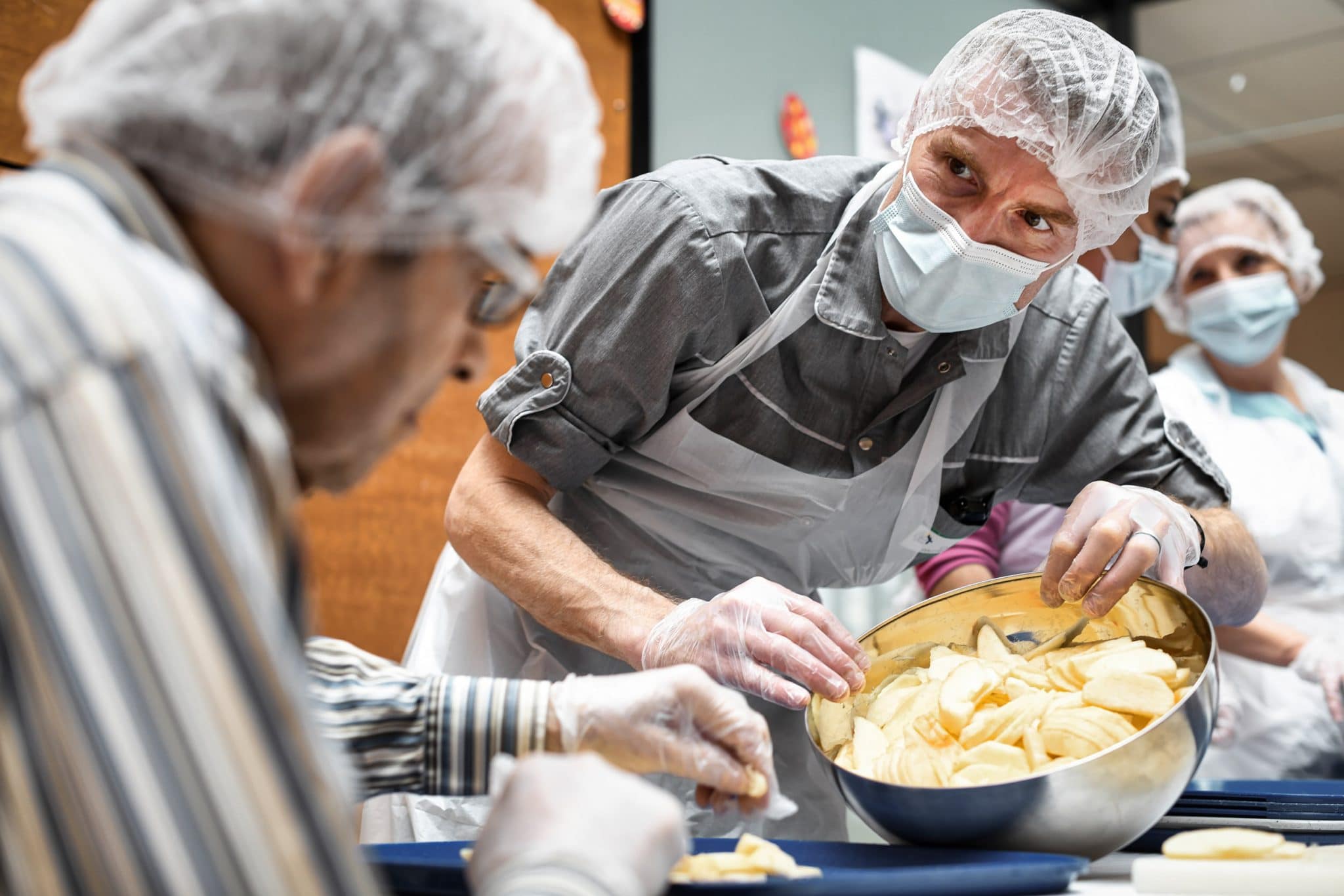 Photographe professionnel Santé à Paris. EHPAD Sainte Emilie. Animateur en séance d'atelier culinaire avec des résidents Alzheimer