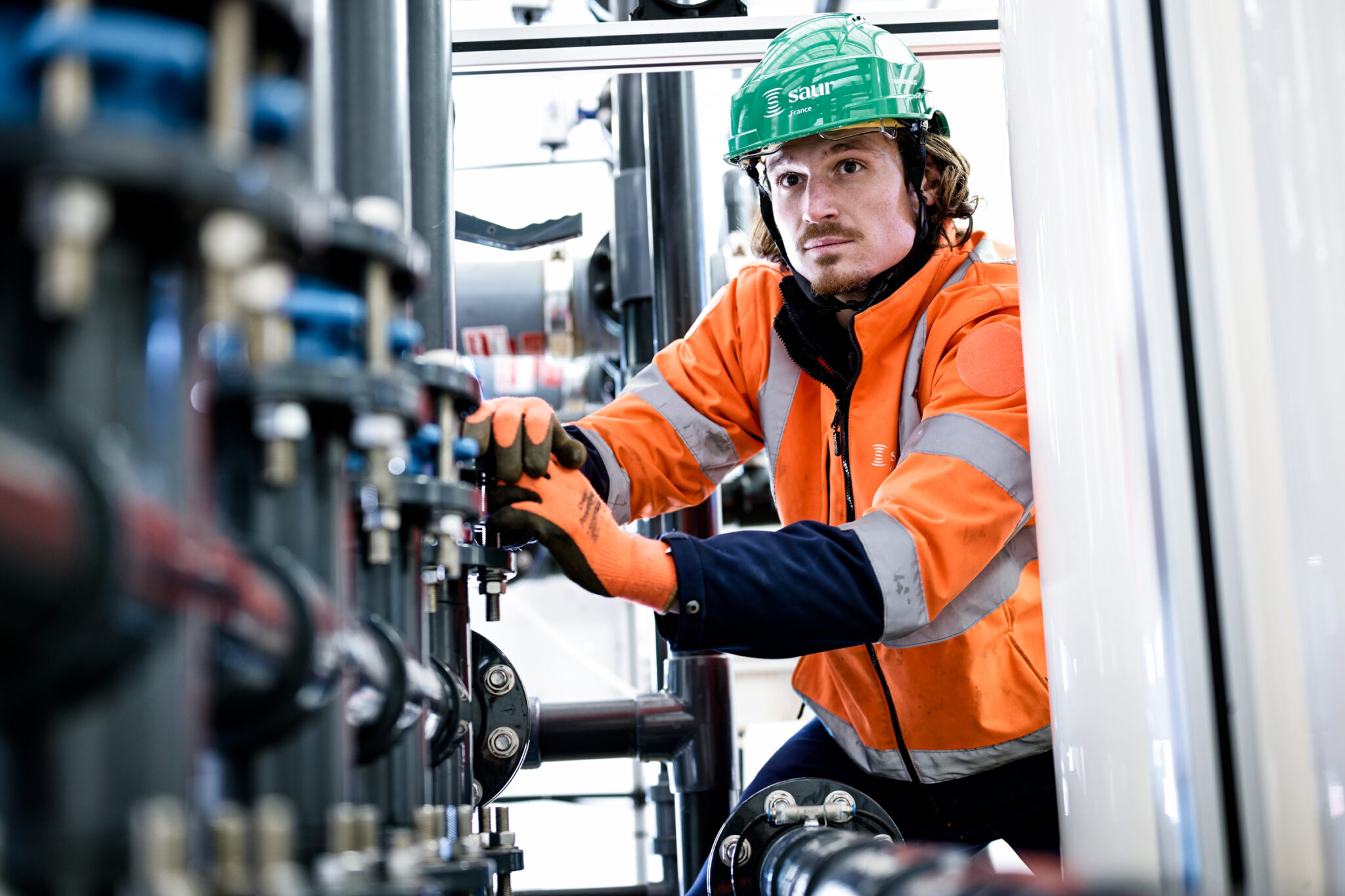 Un employé de la SAUR en maintenance dans un local technique en région PACA.