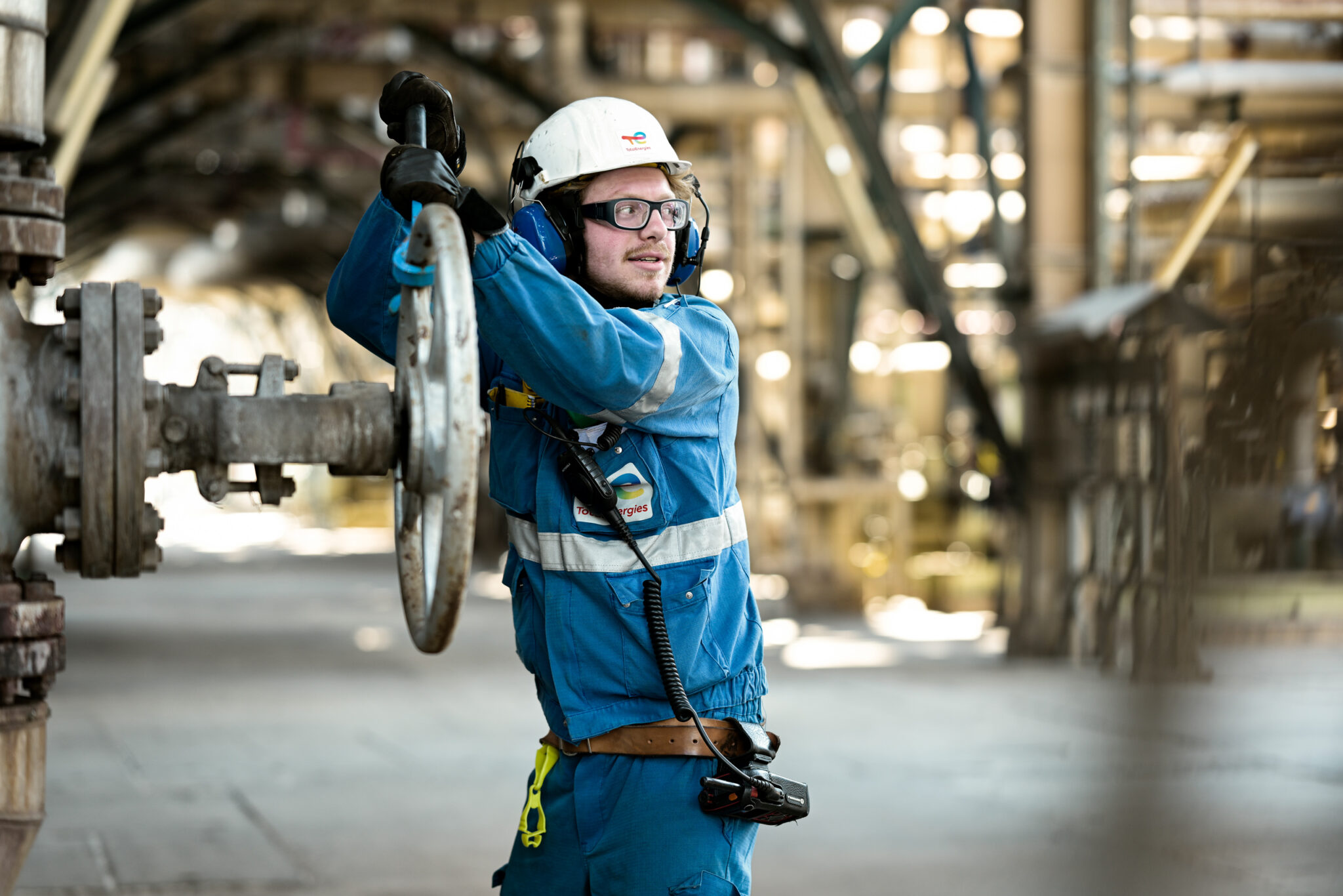 reportage photo en raffinerie; ouvrier de maintenance manipule une vanne dans la raffinerie de Totalenergies à Anvers; photographe industriel