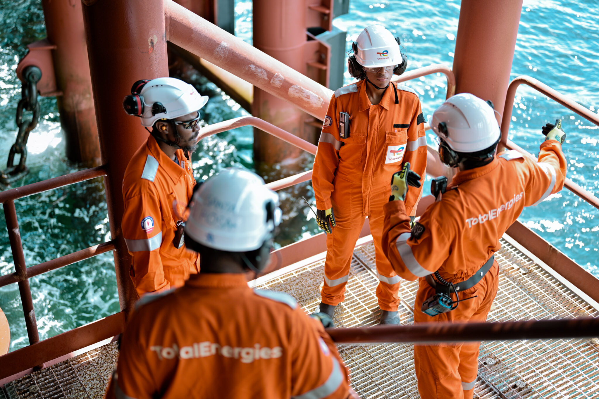 4 employés de TotalEnergies en discussion sur les coursives du FPSO CLOV en Angola.